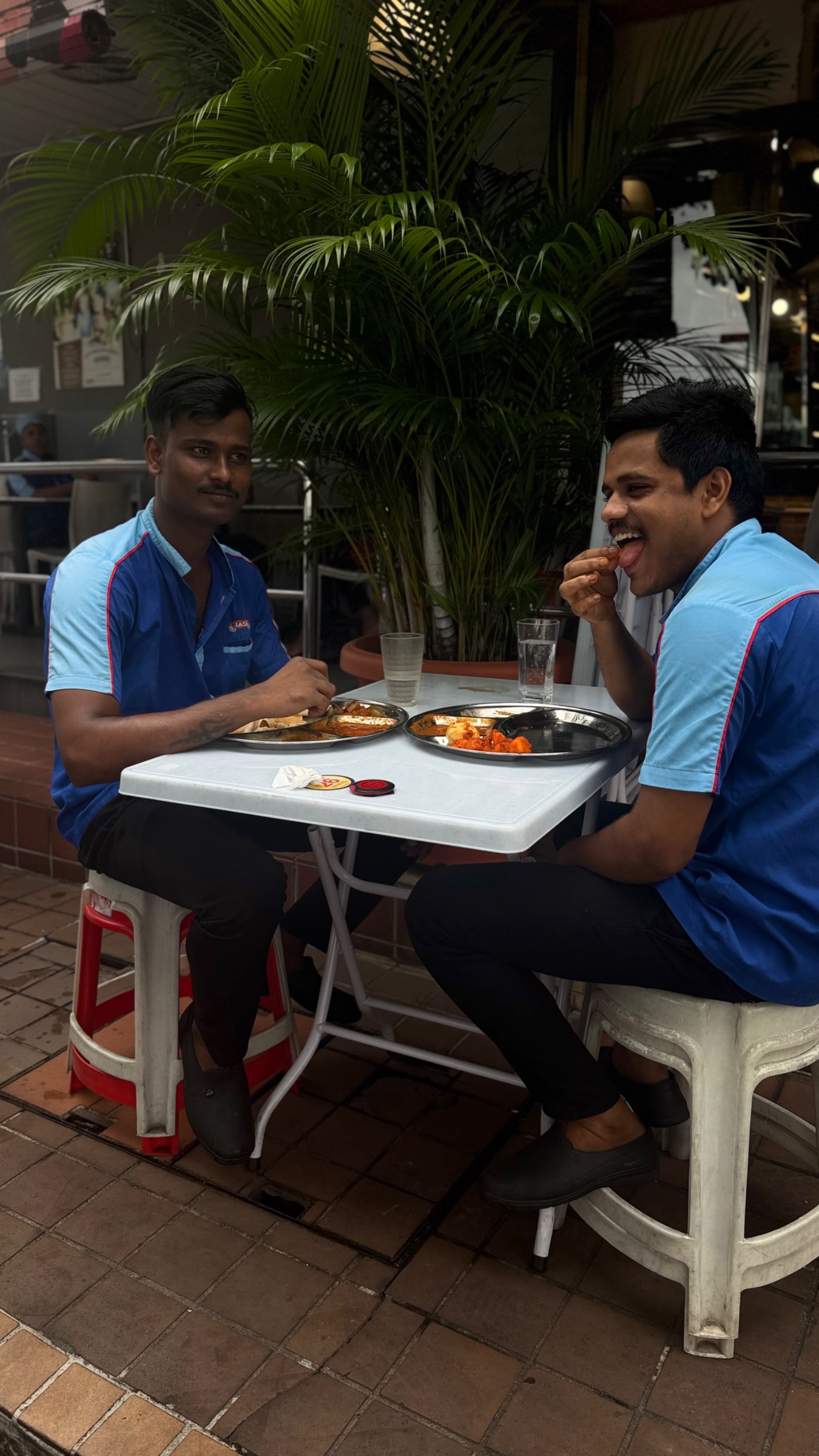 2 waiters eating breakfast together not hidden out the back