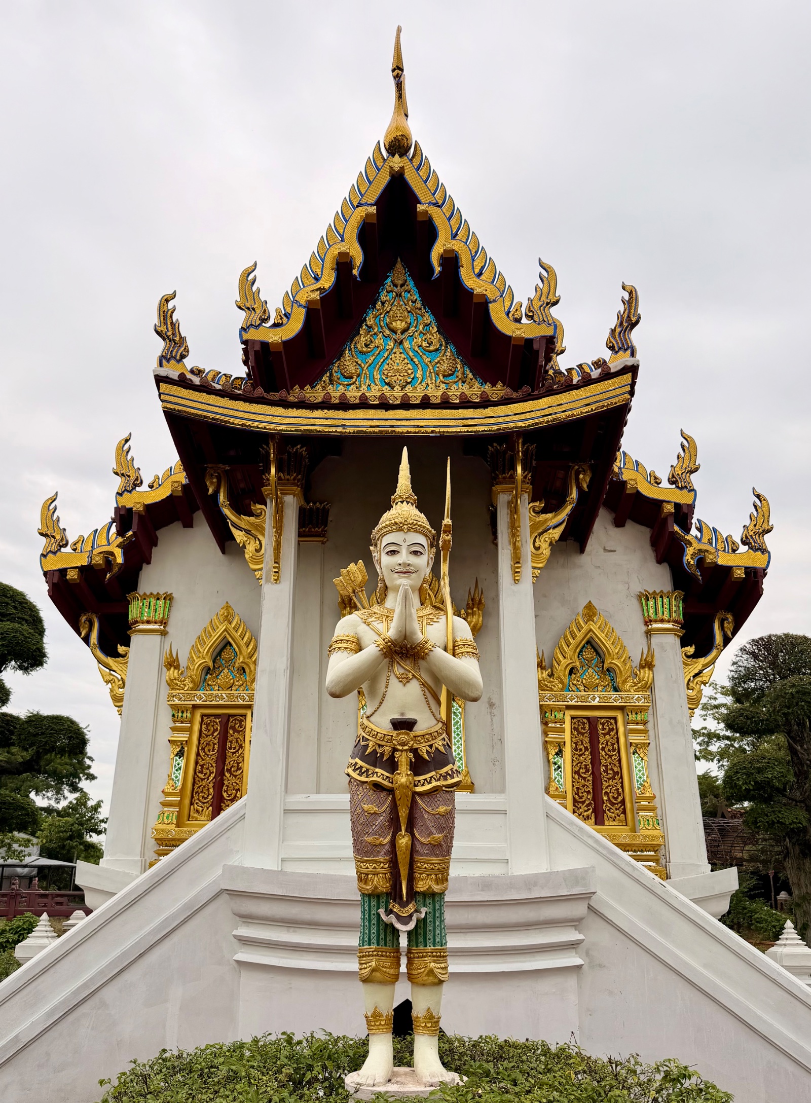 Budha in prayer outside guilded temple